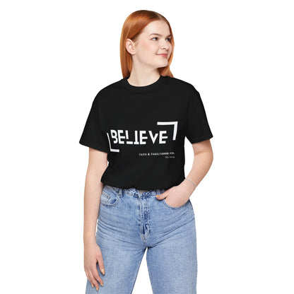 A close-up of a black Believe Shirt with the word "BELIEVE" in bold, white lettering, along with the Faith & Familyhood Co. logo and the year "Est. 2014."